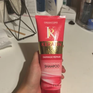 Keratin Pro Damage Repair Shampoo - Keratin Pro Damage Repair Shampoo från Creightons i en snygg rosa och guldig tub på 250 ml. Schampot är berikat med keratin och är perfekt för att stärka och återfukta håret. Cruelty free och med naturliga ingredienser.