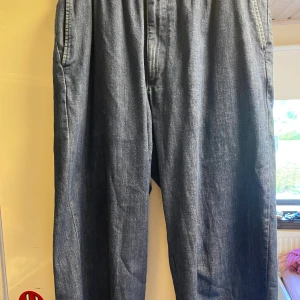 Byxor med jeans-material - Blåa byxor med jeans-material, men betydligt mycket bekvämare än vanliga jeans. Byxorna har resår i midjan och snörning. Avslappnad modell med fickor. Köpte byxorna för 300 kr vid nypris