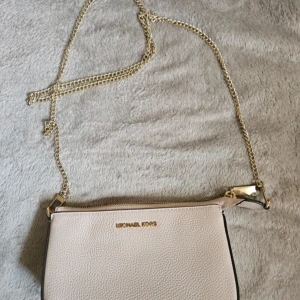 Michael Kors Väska - Liten väska som rymmer det viktigaste! Följer med en lång kedja och den kortare originalkedjan som tyvärr gått sönder!