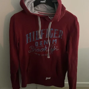 Hilfiger denim hoodie vinröd - Säljer en vinröd hoodie från Hilfiger Denim. Modellen är ca 180 cm. Hör av dig vid funderingar!