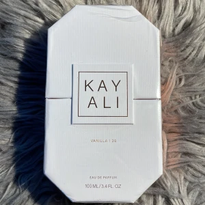 Kayali Vanilla | 28 EdP 100ml - Kayali Vanilla | 28 Eau de Parfum, 100ml. Nyckelnoter: vaniljorkidé, tonkaböna, brunt socker, amber woods och mysk. Ingredienser och detaljer finns på förpackningen. Tillverkad i Frankrike.