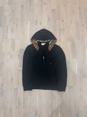 Svart Burberry hoodie - Säljer en svart burberry hoodie i storlek M. Den är i mycket bra skick inte använd. Pris kan diskuteras vid snabb affär. Kom privat för fler frågor 