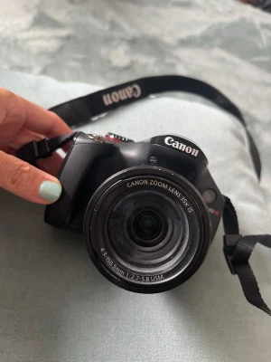 Canon PowerShot SX30 IS - Canon PowerShot SX30 IS digitalkamera med 35x optisk zoom, bildstabilisering och ultrasonisk motor. Kameran ser ut att vara i gott skick och levereras med originalrem och väska. Perfekt för både nybörjare och entusiaster.