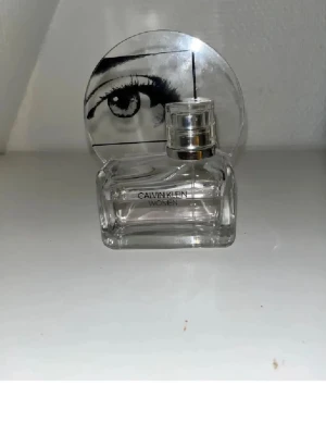 Calvin Klein Women 50ml parfym - Stilren parfym från Calvin Klein med unik design och coolt ögonmotiv på korken. Volymen är 50 ml, perfekt storlek att ta med i väskan. Passar dig som gillar trendiga detaljer och vill sticka ut.