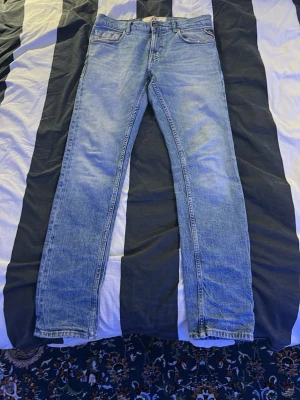 Replay jeans Mickym - Säljer ett par klassiska ljusblå jeans från Replay med raka ben och femficksmodell. Jeansen har normal midja och är tillverkade i slitstarkt bomullsmaterial. Snygg tvätt och diskreta detaljer gör dem perfekta till alla outfits.