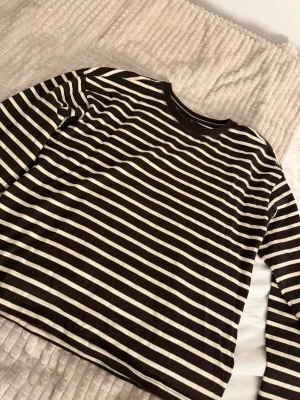 Brun och vit randig tröja  - Säljer en långärmad tröja med bruna och vita  ränder. Köpt från Nelly och säljer för att den var lite för liten för mig. Den är helt OANVÄND. 
