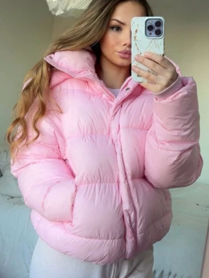 Bik Bok Jacka 💕 - Säljer en populär rosa pufferjacka från BikBok i storlek XS. Jackan har huva, dragkedja och knappar framtill samt ribbade muddar vid ärmslut. Perfekt för kalla dagar och har en riktigt mysig vibe. Har några fläckar här och var 🩷