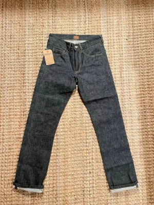 Svarta jeans från Morris -  Säljer ett par Morris Red Selvedge jeans i mörk denim.W30 L32 Jeansen är helt nya, aldrig använda och med originaltagg kvar. Måtten är midja:37 innerbens längd:109 benöppning:19(öppen för bud😁)