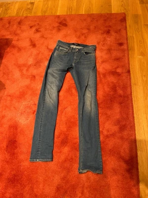 Replay Hyperflex blå jeans - Säljer ett par Replay Hyperflex jeans i klassisk blå färg med raka ben och snygga detaljer på bakfickorna. Jeansen har normal passform och är tillverkade i stretchigt jeansmaterial för extra komfort. Perfekt för dig som vill ha stilrena och bekväma jeans.