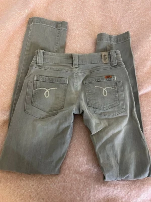 Ljusgrå Object jeans med raka ben - Snygga ljusgrå jeans från Object med raka ben och klassiska detaljer på bakfickorna. Jeansen har fem fickor, bälteshällor och subtila sömmar. Perfekta för dig som gillar en enkel men stilren look. De är ganska små i storleken! Skulle säga att de passar xxs