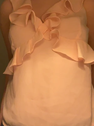 Ljusrosa volangtopp med knyt - Supersöt ljusrosa topp med volangdetaljer och knyt i ryggen. Jag köpte toppen på Missäy för några månader sedan men har knappt använt den, så den är i jättebra skick 💞 Pris går att diskutera! 