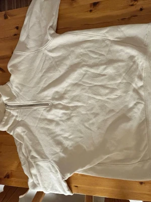 Vit half zip tröja från Zara - Säljer en clean vit tröja från Zara med half zip-dragkedja och hög krage. Tröjan är i mjukt material och har lång ärm, perfekt för lager på lager under kyliga dagar. Enkel och stilren design som funkar till det mesta.