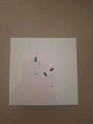 Apple Airpods gen 3 - Säljer ett par vita Apple AirPods med MagSafe-laddningsetui. Snygg och stilren design i plast, perfekt för dig som vill ha trådlösa hörlurar med grym ljudkvalitet och enkel anslutning till iPhone. Smidig laddning med MagSafe och kompakt format.