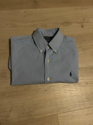 Blå Ralph Lauren Skjorta Storlek M - Klassisk Ralph Lauren skjorta i blå färg. Tröjan är i bra skick, sparsamt använd. ~  Storlek: 15/38 Motsvarar ungefär M | Skick: Bra skick! | Färg: Blå | Märke: Ralph Lauren | Modell: Skjorta |     | Hör gärna av dig vid frågor så svarar jag så fort jag kan! 😁  