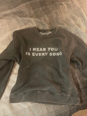Mörkgrå sweatshirt med text - Cool mörkgrå sweatshirt med text skriven i silvriga stenar strl S. Använd en gång
