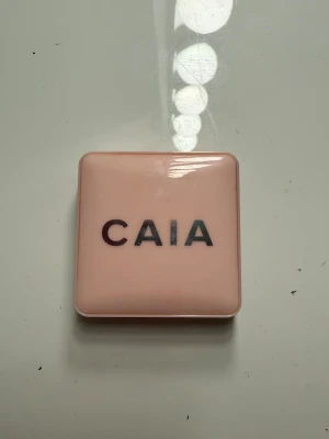 CAIA bronzer/blush/blonzer - Säljer en bronzer/blush från CAIA i en snygg ljusrosa kompakt med spegel. Pudret har en varm, gyllenbrun ton med lätt skimrig finish som ger glow till ansiktet. Perfekt att ha i väskan för touch-ups under dagen. I färgen HOT TOAST