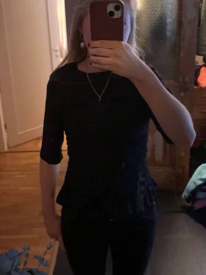 Svart topp med volangdetalj - Säljer en svart topp från hm med en volang i änden av tröjan. Den är använd fåtal gånger och är i fint skick. Skriv vid fråger och funderingar🥰❤️