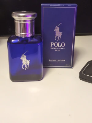 Polo Blue parfym från Ralph Lauren - Fräsch och maskulin parfym från Ralph Lauren, Polo Blue. Flaskan är djupblå med silverfärgat lock och har den klassiska polospelaren i silver på framsidan. Kommer i originalkartong. Eau de toilette, 40 ml.