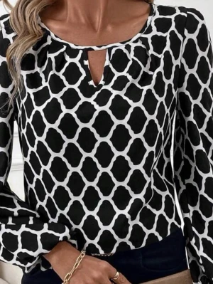 Svartvit mönstrad blus - Snygg svartvit blus med grafiskt mönster och rund halsringning med liten v-ringning framtill. Blusen har långa ärmar med resår vid handlederna och är tillverkad i ett lätt, mjukt tyg som ger ett avslappnat fall.