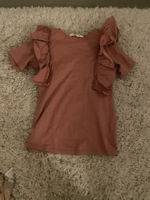 Rosa topp med volangdetaljer -  Säljer en super gullig rosa topp 💗💗 Jag tycker att den är ganska stor i storleken💗💗