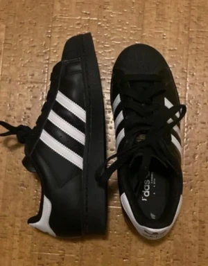 Adidas Superstar svarta sneakers - Helt nya, svarta Adidas Superstar sneakers med gulddetalj🫶
