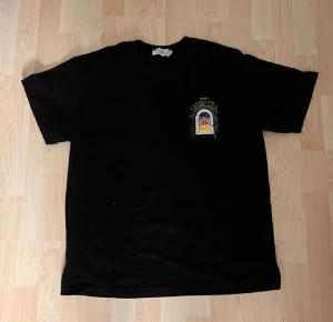 Svart Casablanca t-shirt med tryck - Svart t-shirt från Casablanca Tennis Club med färgstarkt tryck på både bröstet och ryggen. T-shirten har rund hals och korta ärmar med en avslappnad fit, perfekt för en chill och stilren look.