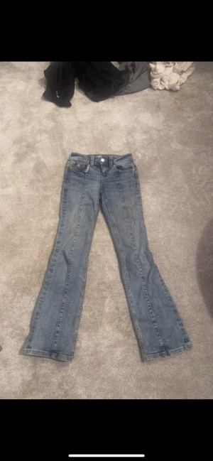 Blå bootcut jeans från Perfect Jeans - Snygga blå jeans från Perfect Jeans i storlek 32 med klassisk bootcut passform. Jeansen har fem fickor, bälteshällor och dragkedja med knapp. Materialet är slitstarkt denim och färgen är en tvättad blå ton med kontrastsömmar. Är från Gina tricot 