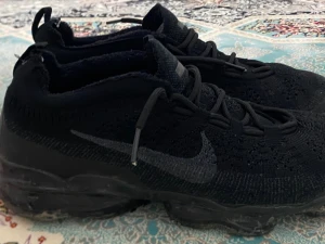 Nike Vapormax  - Nike Vapormax sneakers i helsvart. Nypris ligger på 2000kr. Har använt dem i 6 månader. Sulan är lite trasig men det funkar felfri ändå. Storlek 43.