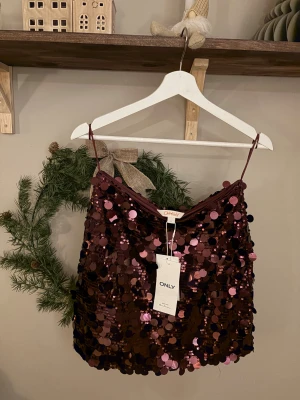 Vinröd paljett kjol från ONLY - Säljer en helt ny vinröd paljettkjol ifrån Only kjolen är slutsåld på nätet säljer den då small blev förstort för mig som är en xs i strl 