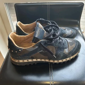 Valentino Rockrunner sneakers camouflage - Snygga Valentino Rockrunner sneakers med mörkblå  camouflage-mönster, detaljer i mocka och skinn samt coola nitar runt hälen och sulan. Box medföljer, kontakta vid seriöst intresse!