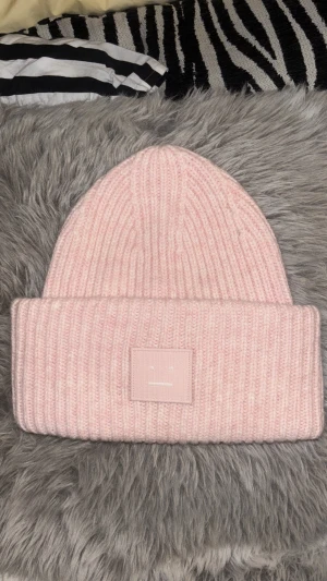 Stickad rosa mössa från Acne Studios - Säljer en stickad mössa från Acne Studios i ljusrosa färg med ribbad struktur och den klassiska Acne Studios-loggan framtill. Använd nån gång men jätte bra skick!🌸kom med egna prisförslag