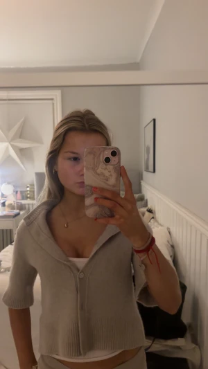 Beige kofta från & Other Stories XS - Superfin beige kofta från & Other Stories med ribbade detaljer och knappar framtill. Modellen har halvlånga ärmar och en lite croppad passform. Perfekt att slänga över ett linne för en chill men ändå snygg look.