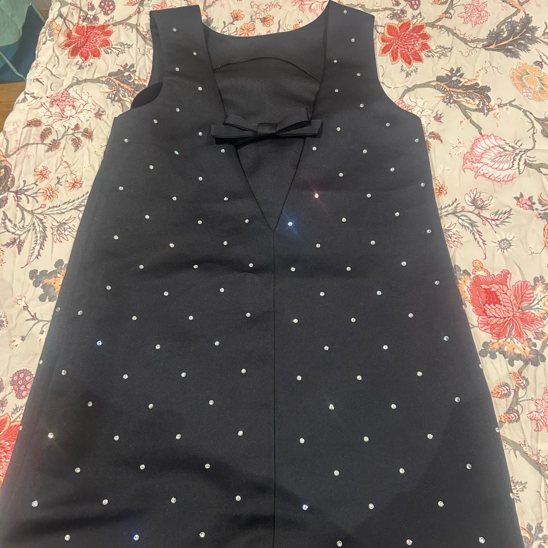 Svart kortklänning med pärlor och rosett - 1