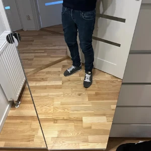 Dondup George w 31 - Snygga mörkblå jeans med skinny passform och klassiska fem fickor. Jeansen har dragkedja i gylfen och smal siluett som sitter tajt längs benen. Perfekta för dig som gillar en modern och stilren look.