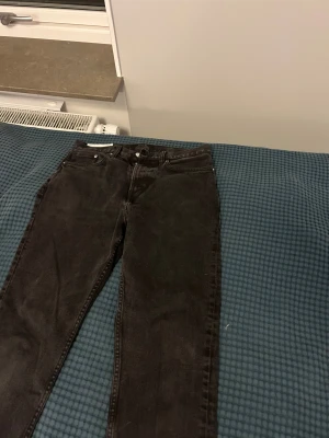 Svarta skinny jeans från H&M - Snygga svarta jeans från H&M med klassisk femficksdesign och smal passform. Jeansen har en mörk tvätt och raka ben, tillverkade i slitstarkt denim. Perfekta för dig som gillar en clean och enkel look.
