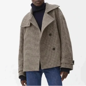 Rutig skepparkavaj i ullmix - Säljer en oversized skepparkavaj med brunt och beige rutigt mönster, bred krage och dubbelknäppning. Jackan har långa ärmar med knappar vid mudden och är tillverkad i en ullblandning som ger en schysst och klassisk vibe.