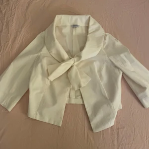 Vit bolero  - Fin vit vintage bolero i strl M med stor rosett vid framsidan