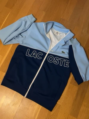 Blå zip tröja från Lacoste - Säljs eftersom den inte används. Jätte fint skick utan defekter. Skriv vid funderingar!😊