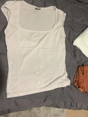 Ljusrosa linnetopp från Gina Tricot - Säljer en ljus rosa linnetopp från Gina Tricot med fyrkantig urringning och ärmlös design. Toppen är gjord i mjuk bomull och har en clean, enkel look som är lätt att matcha med olika outfits. Perfekt för varma dagar och layering.