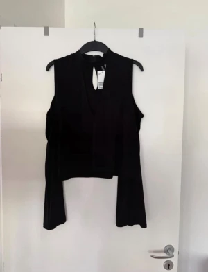 Topp svart  - Öppna axlar och öppen vid urringningen. Storlek XL. Aldrig använd. 