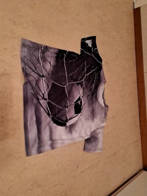 Grå t-shirt med fotbollstryck - Säljer en grå t-shirt med ett stort tryck av en fotboll som går in i nätet. T-shirten har korta ärmar och är gjord i mjukt material, perfekt för dig som gillar sportig stil. Motiv i svart och vitt som verkligen sticker ut. I nytt skick. Säljs för 75 kr. Tveka inte att kontakta om du är intresserad eller har några frågor! Först till kvarn dom gäller!