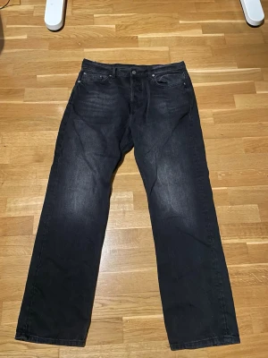 Svarta Weekday jeans 32/32 - Säljer ett par svarta jeans från Weekday i storlek 32/32. De har en rak passform med klassisk femficksdesign och är tillverkade i 100% bomull. Snyggt tvättade detaljer
