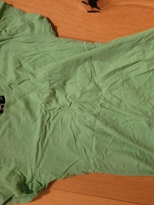 Grön basic t-shirt i bomull - Enkel grön t-shirt med rund hals och korta ärmar. Tillverkad i mjuk bomull som känns skön mot huden. Perfekt till jeans eller shorts för en avslappnad look.