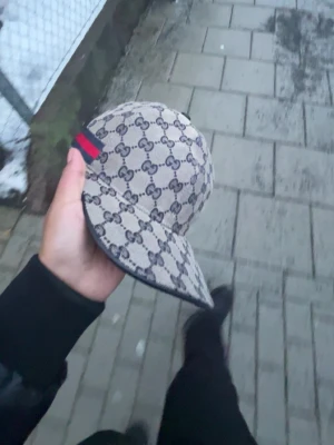 Gucci beige GG-mönstrad keps - Säljer en beige och marinblå keps från Gucci med klassiskt GG-mönster över hela kepsen Helt ny!! Möts i gbg storlek m den är som sagt helt ny du får med bagen o lapparna. Kom med bud!