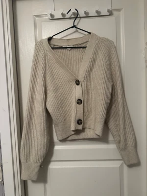 Ribbad kofta  - Säljer en beige ribbad kofta från H&M i storlek XS. Koftan har v-ringning, stora knappar framtill och långa ärmar med breda muddar. Riktigt mysig under tidig vår😽💋