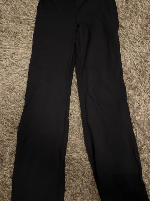 Marin blå leggings från Gina Tricot - Marin blå leggings från Gina Tricot i stretchigt material. De har en medelmidjad omlottdesign i midjan som ger en snygg och modern look. Perfekta att matcha med en oversized hoodie eller crop top.