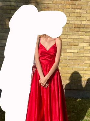 Röd balklänning - En röd balklänning från JJ’s house! Förmodligen i stl 32/34, passar mig som är xs/s. Fint skick, använd en gång! Korsade band i ryggen som går att justera, även en dragkedja. Färgen från hemsidan stämmer inte helt överens, utgå från de egna bilderna! Skriv vid frågor!