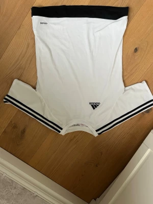 Vit Adidas t-shirt med svarta shorts - Säljer en vit Adidas t-shirt och svarta matchande shorts till, bra tränings kläder. Shortsen har avklippt lapp men är nog i storlek S och tröja i 164!