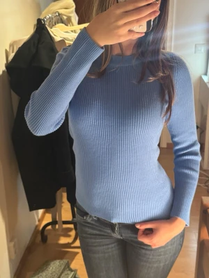 Ljusblå ribbad stickad tröja - Supersnygg ljusbla stickad tröja med ribbad struktur och lång ärm. Helt ny!