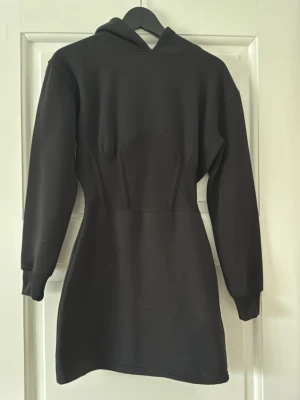 Korsettklänning Missguided - Svart korsettklänning i hoodiematerial från Missguided i storlek 38, aldrig använd (lapp kvar). 